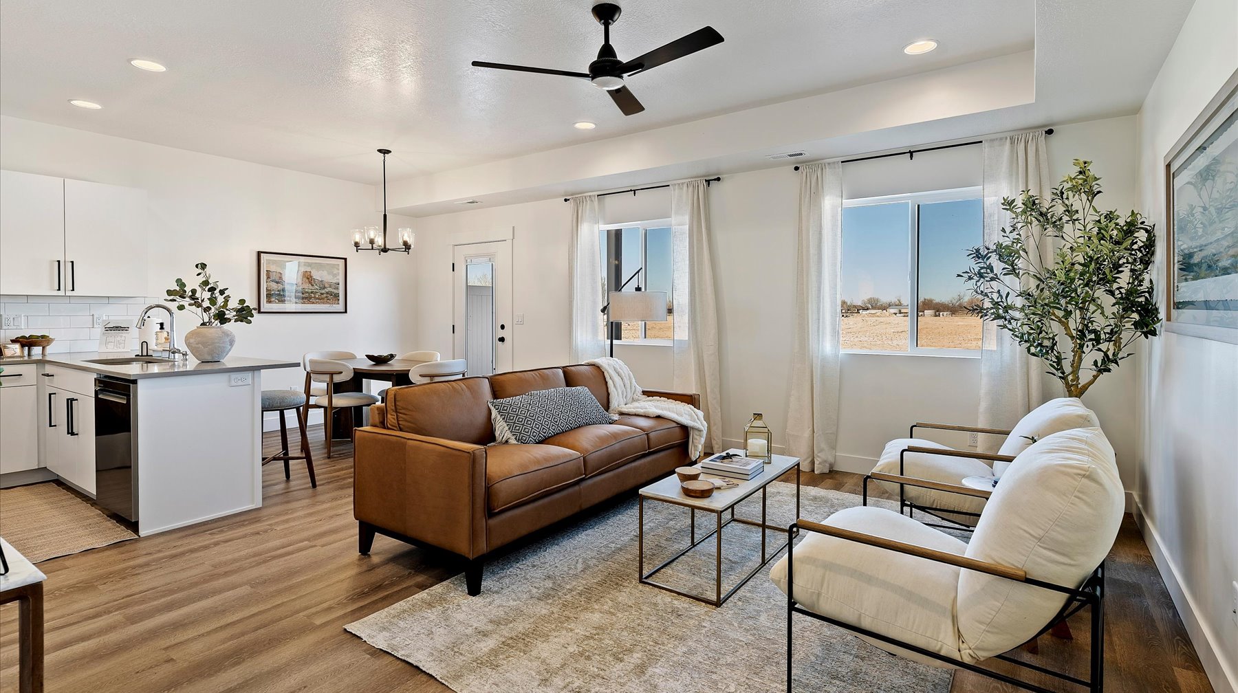 Living room with a ceiling fan, a chandelier, and light wood finished floors