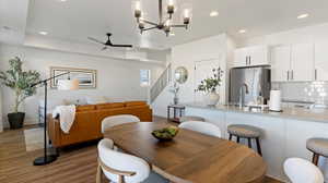 Dining area featuring suspended lighting, ceiling fan, and dark wood-style flooring