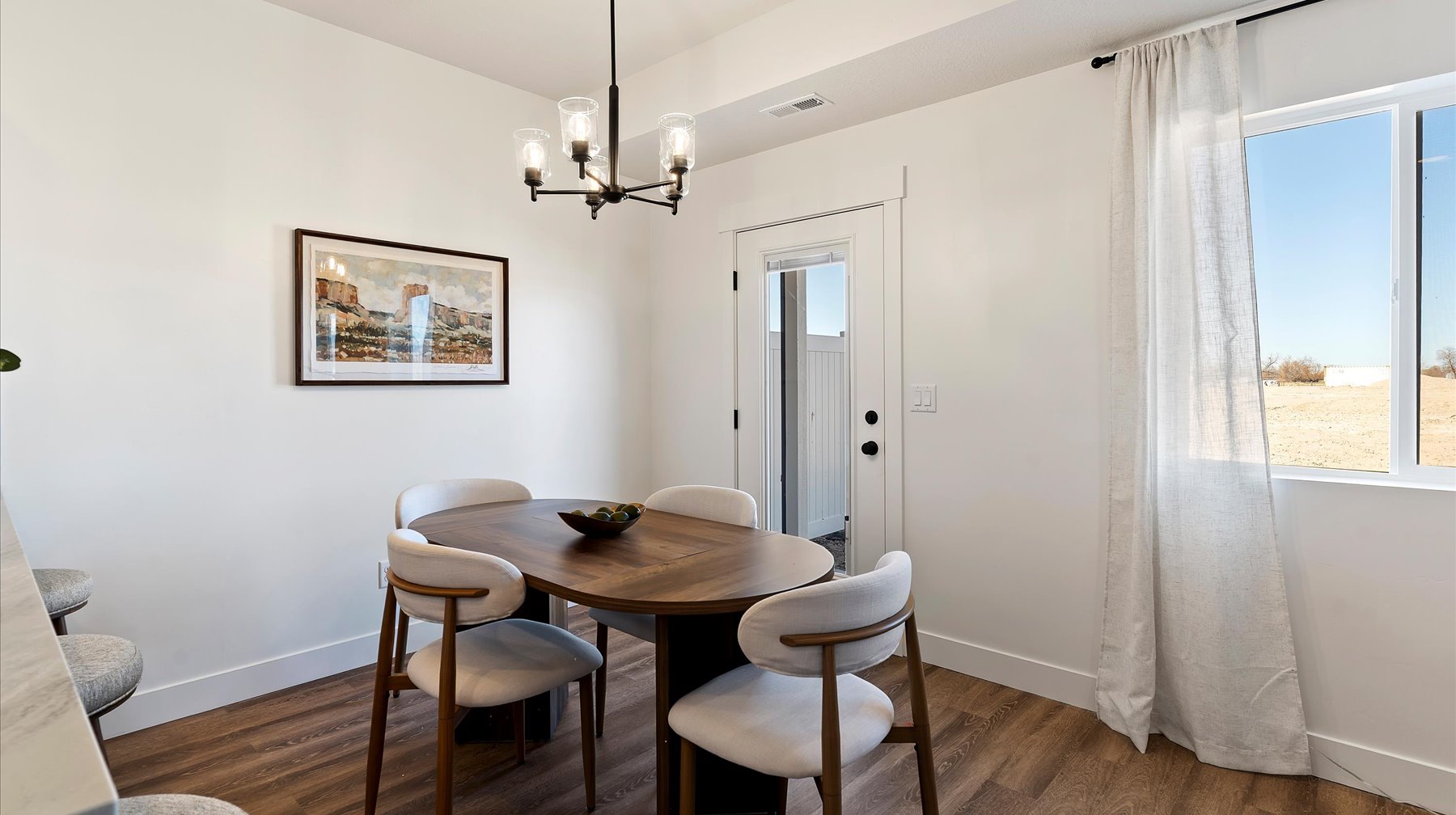 Dining area featuring dark wood-style flooring and suspended lighting