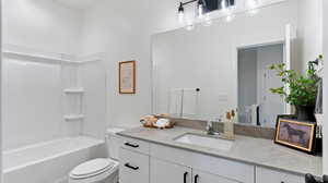 Bathroom featuring vanity and washtub / shower combination
