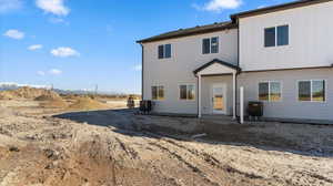 Back of property with board and batten siding and a patio