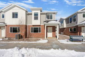 View of front of house featuring brick siding and board and batten siding