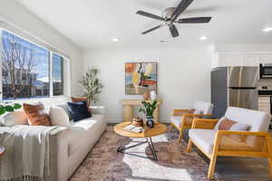 Living area with ceiling fan, wood finished floors, and recessed lighting