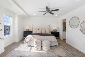 Bedroom with carpet flooring, a ceiling fan, and ensuite bathroom