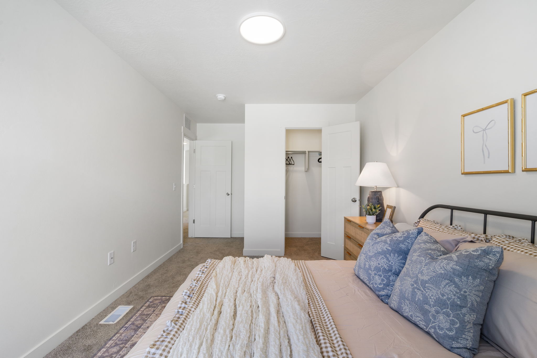 Bedroom featuring light carpet and a spacious closet