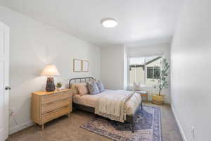 Bedroom featuring carpet floors and baseboards