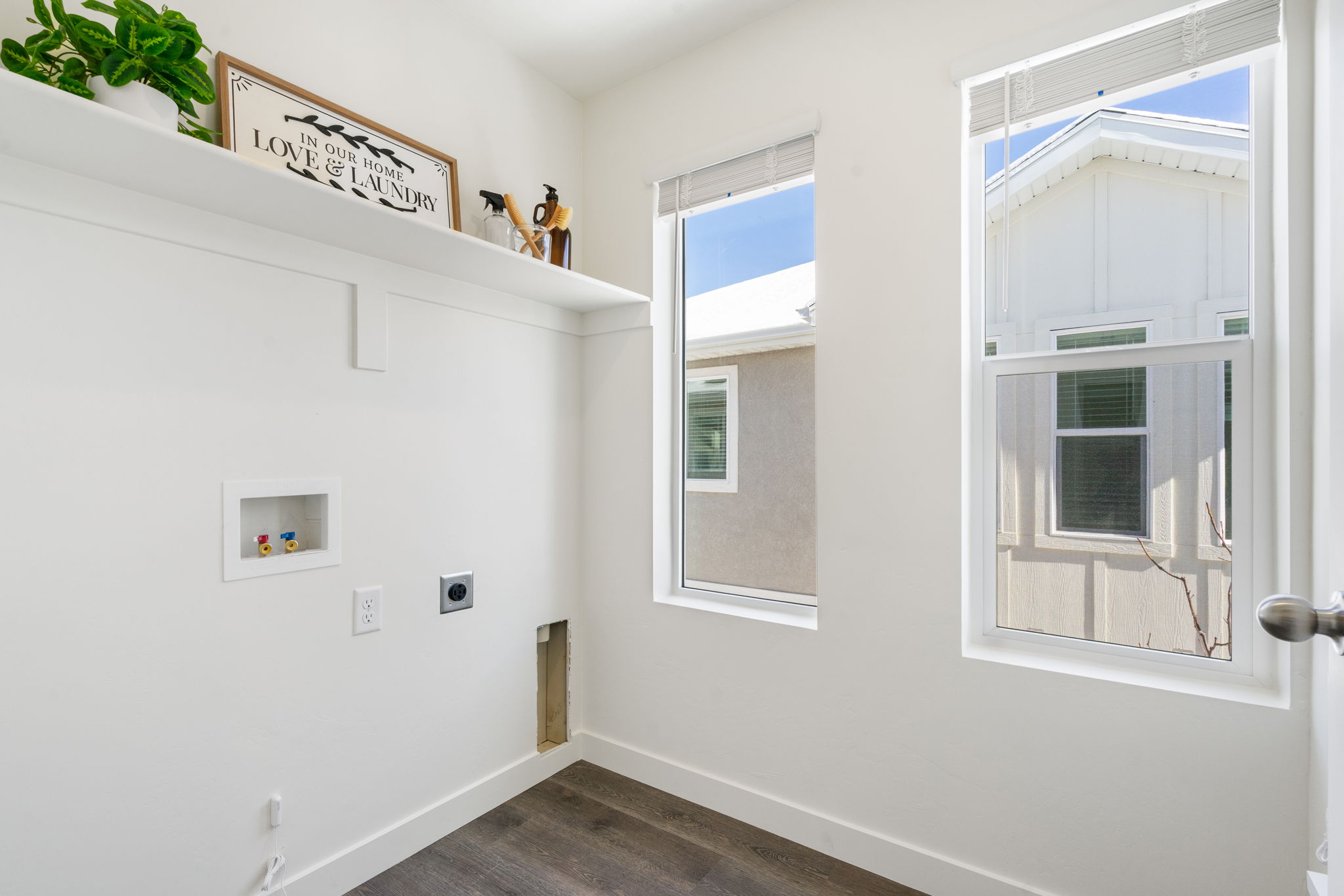 Laundry area with electric dryer hookup, hookup for a washing machine, and dark wood-type flooring