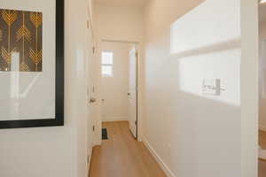 Hall with light wood-type flooring and baseboards