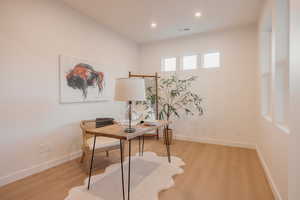 Home office with wood finished floors and recessed lighting