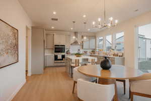 Dining space featuring light wood-type flooring and a chandelier
