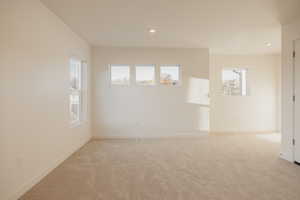 Empty room featuring light colored carpet and recessed lighting