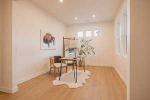 Office area featuring light wood-style floors and recessed lighting