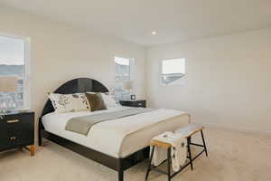 Bedroom with light colored carpet and recessed lighting