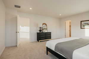 Bedroom featuring recessed lighting, light carpet, and a walk in closet