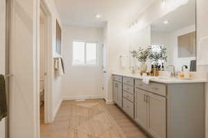 Bathroom with double vanity, light wood-style floors, and recessed lighting