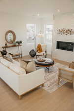 Living area featuring a fireplace, light wood-type flooring, and recessed lighting