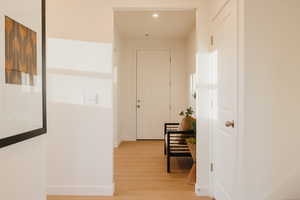 Hallway featuring light wood-style floors and recessed lighting