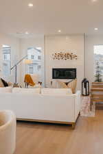 Living area featuring plenty of natural light, wood finished floors, recessed lighting, and a fireplace