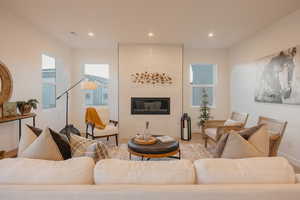 Living room with a fireplace, wood finished floors, and recessed lighting
