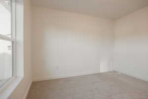 Carpeted empty room featuring baseboards