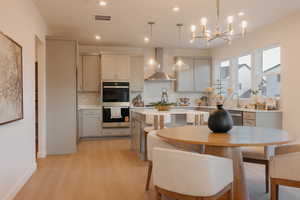 Dining room with light wood-style flooring and hanging lights