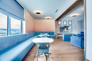 Living area featuring light wood-style floors and beamed ceiling