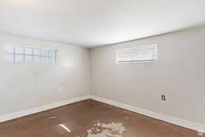 Spare room with baseboards and concrete floors