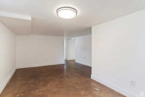 Spare room featuring finished concrete floors and baseboards
