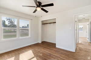 Unfurnished bedroom featuring light wood finished floors, a closet, and a ceiling fan