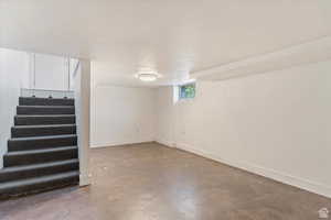 Basement with stairs and baseboards