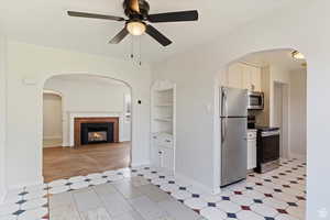 Kitchen featuring stainless steel appliances, ceiling fan, open shelves, and white cabinetry