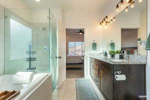 Full bath with ensuite bath, double vanity, and light tile patterned floors