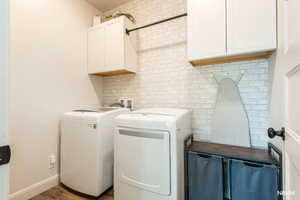 Laundry room with wood finished floors, cabinet space, and separate washer and dryer