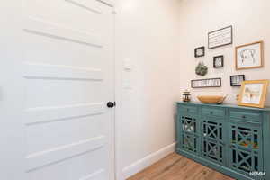 Doorway featuring wood finished floors and baseboards