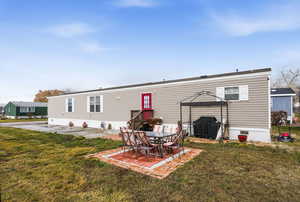 Rear view of house featuring a patio area and a yard