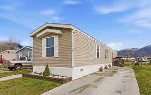 View of home's exterior with a lawn, a mountain view, and crawl space