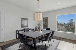 Dining room with dark wood-style flooring and recessed lighting