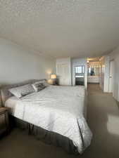 Carpeted bedroom with a closet, molding, and a textured ceiling
