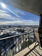 Snow covered back of property with a city view