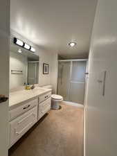 Guest bath featuring vanity, a shower stall, and carpet