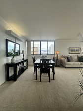 Dining and Living room space featuring light colored carpet and crown molding