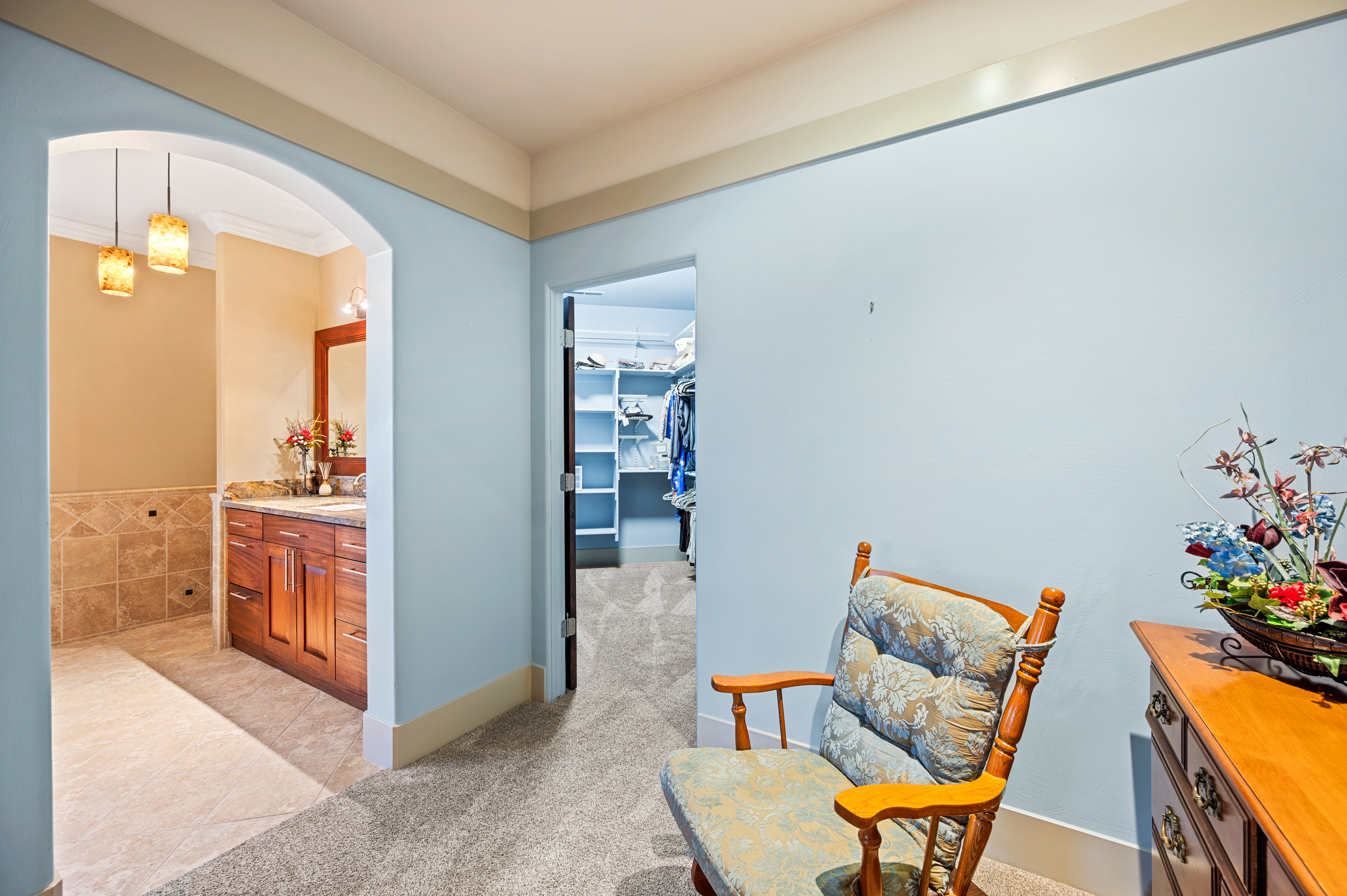 Sitting room with light colored carpet, light tile patterned flooring, and arched walkways
