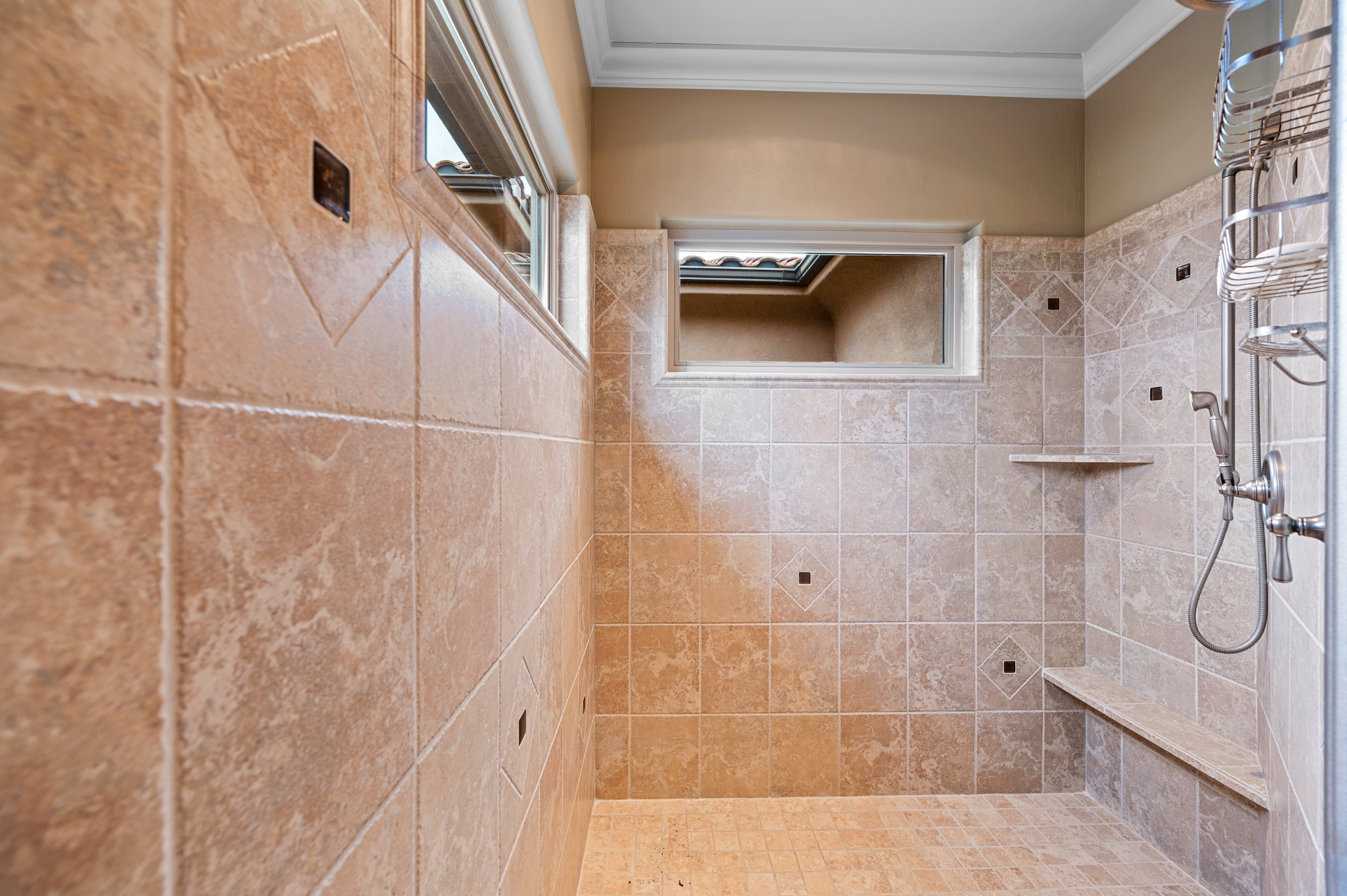 Bathroom with tiled shower and crown molding