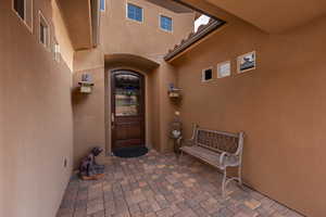 View of exterior entry featuring stucco siding and a patio area