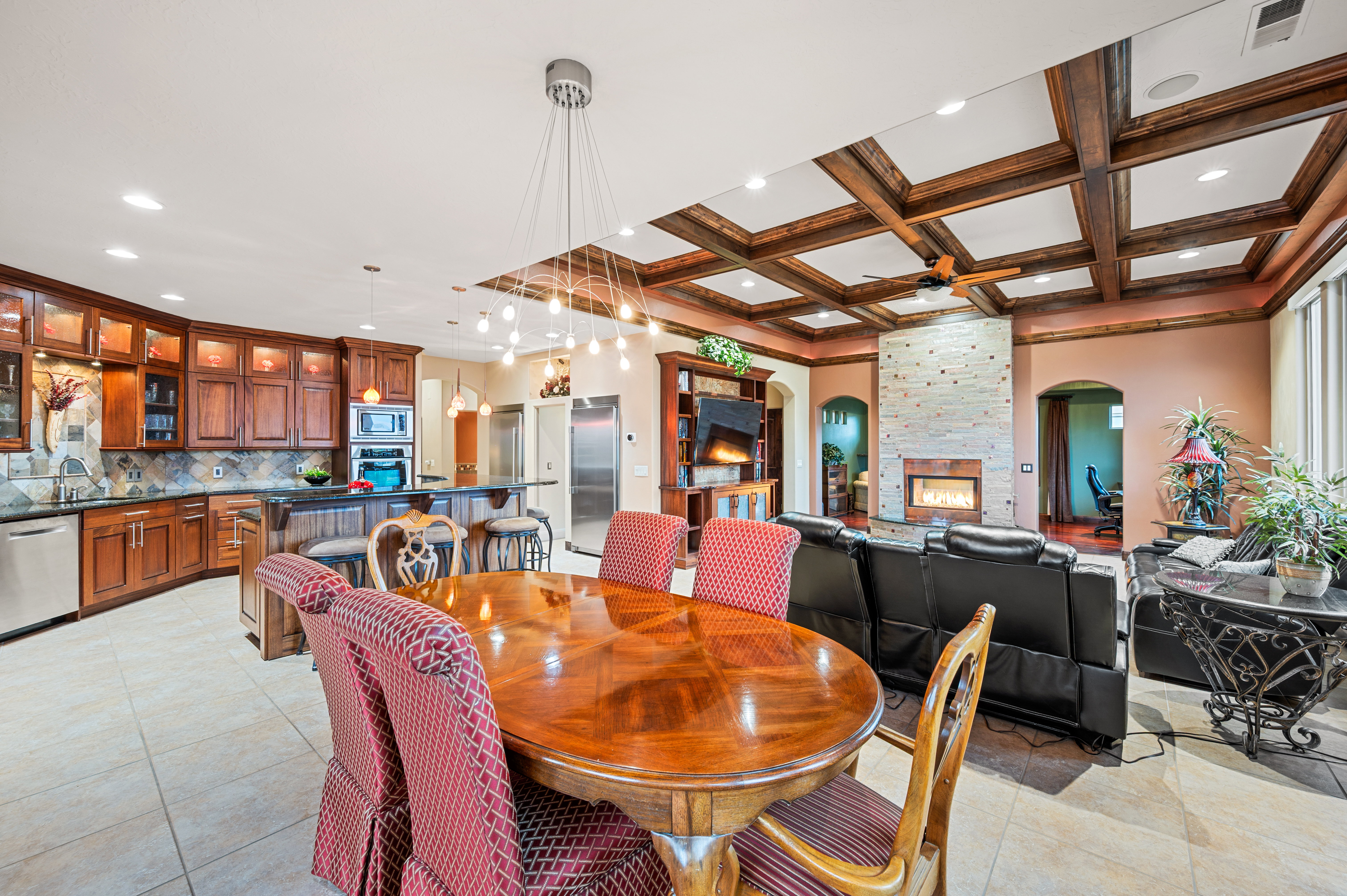 Dining area with arched walkways, recessed lighting, coffered ceiling, a fireplace, and light tile patterned floors
