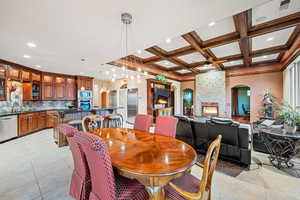 Dining area with arched walkways, recessed lighting, coffered ceiling, a fireplace, and light tile patterned floors