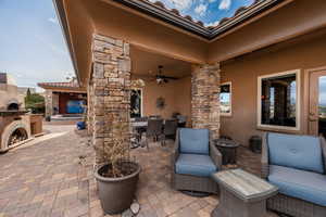 View of patio / terrace with outdoor dining space, ceiling fan, and an outdoor fireplace