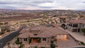 Aerial view of residential area with a mountain backdrop and a golf course