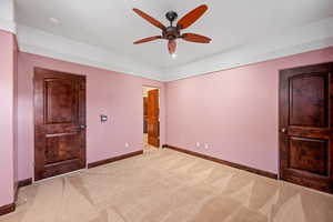 Unfurnished bedroom featuring a ceiling fan and carpet
