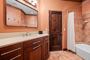 Full bathroom with shower / bath combination with curtain, vanity, and ornamental molding